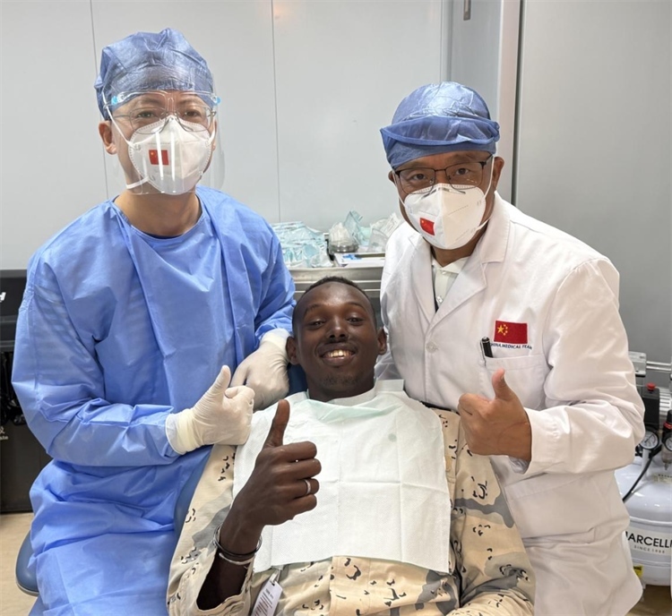 援吉醫(yī)療隊口腔科王瑋主任與“和平方舟”號醫(yī)院船醫(yī)務(wù)人員共同為一名當(dāng)?shù)匮浪柩谆颊咴\療。中國（山西）第23批援吉布提醫(yī)療隊供圖