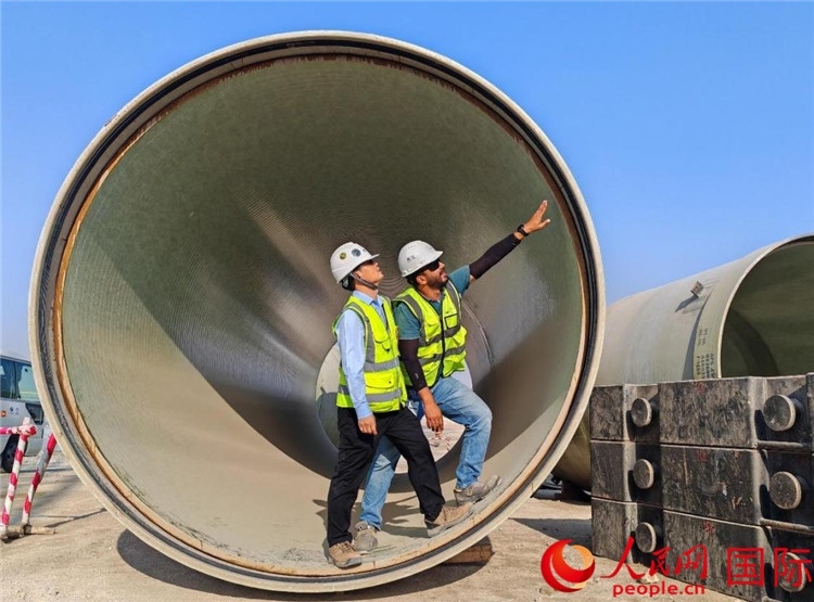 工作人員在察看輸水管情況。人民網(wǎng)記者 管克江攝