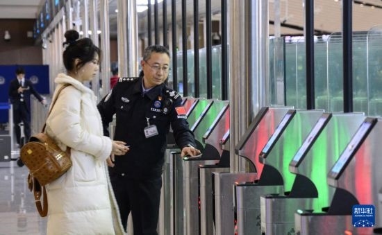 1月2日，大興機場邊檢站警察指導旅客使用自助出境設備。新華社記者 李欣 攝