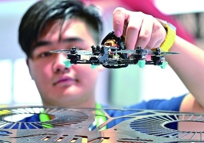 在首屆晉江科技成果轉(zhuǎn)化對接洽談會智能裝備展位，工作人員在展示無人機研究成果。新華社發(fā)