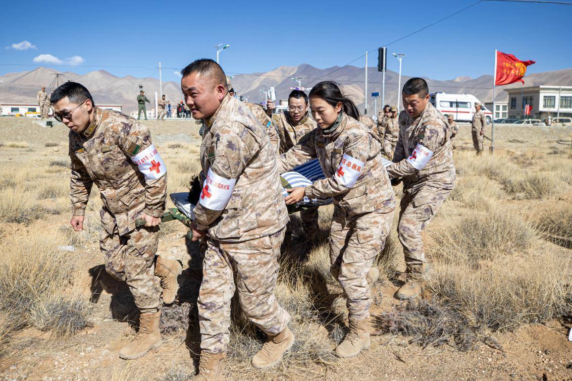 1月9日，日喀則定日縣長(zhǎng)所鄉(xiāng)，西藏軍區(qū)總醫(yī)院醫(yī)療隊(duì)隊(duì)員將受傷村民用擔(dān)架從救護(hù)車(chē)準(zhǔn)備抬上直升機(jī)，轉(zhuǎn)運(yùn)至拉薩的西藏軍區(qū)總醫(yī)院救治。人民日?qǐng)?bào)記者張武軍攝