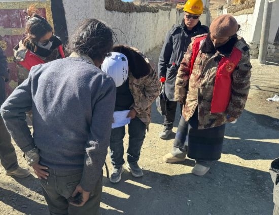 1月13日，次旺（右一）陪同工作組走訪村莊，評估房屋受損程度。新華社發(fā)