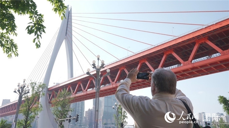 軻寶華“打卡”重慶東水門長江大橋。人民網(wǎng)記者 蘇纓翔攝