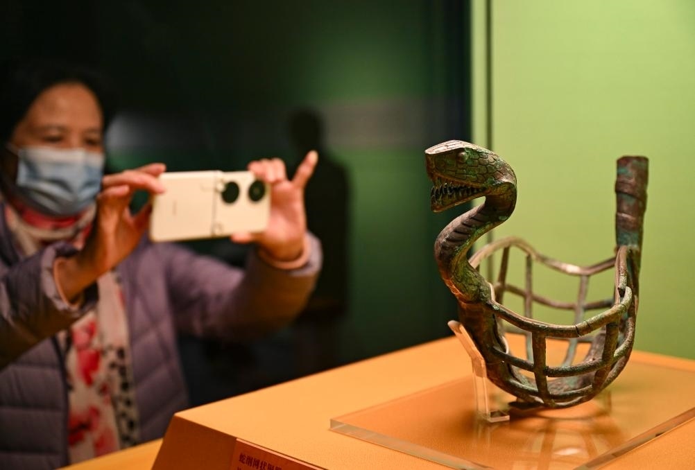 1月14日，觀眾在上海博物館蛇年迎春展拍攝展品蛇綱網(wǎng)狀銅器。新華社發(fā)（陳浩明攝）