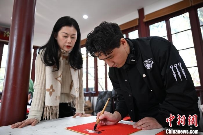 1月20日，外籍留學生在西泠印社社員李硯指導下寫福。當日，來自巴西、馬來西亞、加納、哈薩克斯坦的外籍留學生在浙江杭州西泠印社體驗福貼、春聯(lián)和篆刻，感受古老的中國傳統(tǒng)文化。中新社記者 王剛 攝