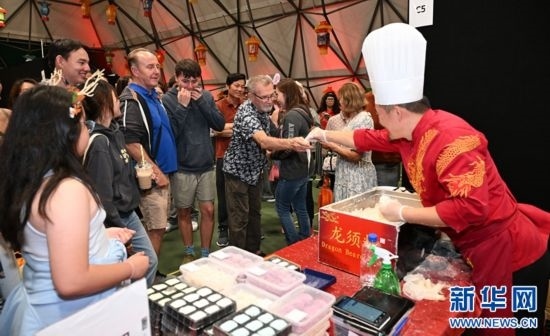 圖為游客在燈節(jié)現(xiàn)場購買小吃。（圖片由奧克蘭中國文化中心提供）