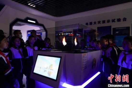 圖為學生們參觀道里區(qū)消防救援大隊消防科普體驗館內(nèi)幻影成像燃燒三要素實驗臺。中新社記者 趙宇航 攝