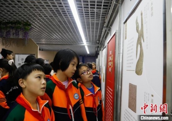 圖為學生參觀青海省博物館“1+3”主題流動展覽，了解木舞俑。中新社記者 馬銘言 攝
