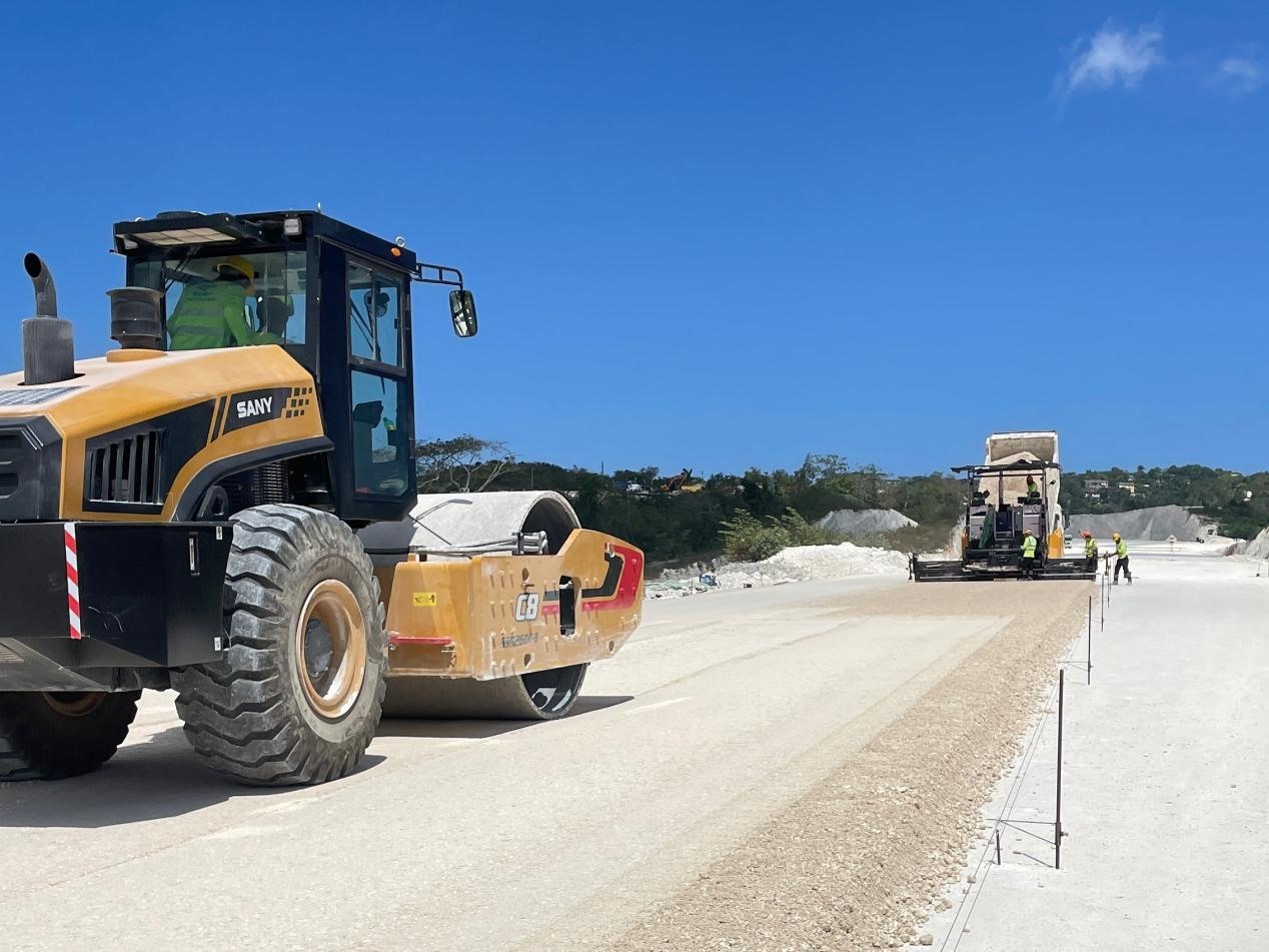 圖為中企承建的牙買(mǎi)加蒙特哥貝繞城路項(xiàng)目基層試驗(yàn)段正在進(jìn)行攤鋪和碾壓施工，相關(guān)施工工作已于日前順利完成。中國(guó)港灣美洲區(qū)域公司供圖