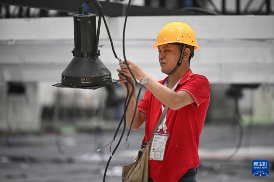 4月4日，工作人員在海南國(guó)際會(huì)展中心內(nèi)布設(shè)燈光。