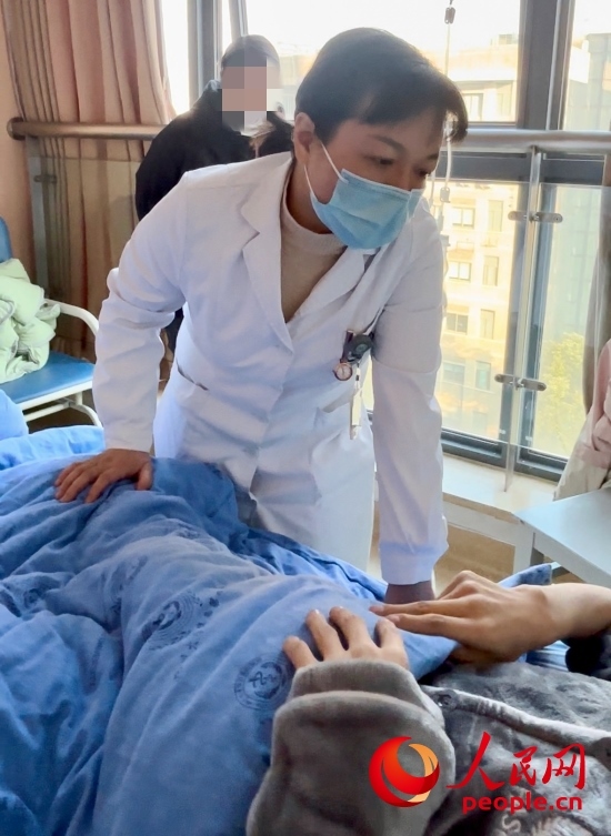 鄧茜查房時(shí)詢問患者情況。人民網(wǎng)記者 金慧慧攝