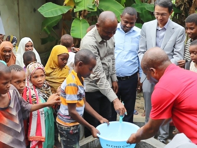 在日前舉行的安全供水工程揭牌儀式上，當(dāng)?shù)匦∨笥言诠┧c(diǎn)接水。 施亮攝