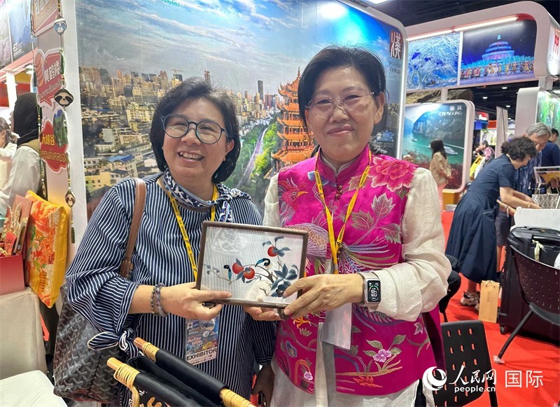 中國(guó)“大冶刺繡”傳承人劉小紅（右）參加泰國(guó)國(guó)際旅游展，向觀眾介紹中國(guó)非遺刺繡針法。人民網(wǎng)記者 簡(jiǎn)承淵攝