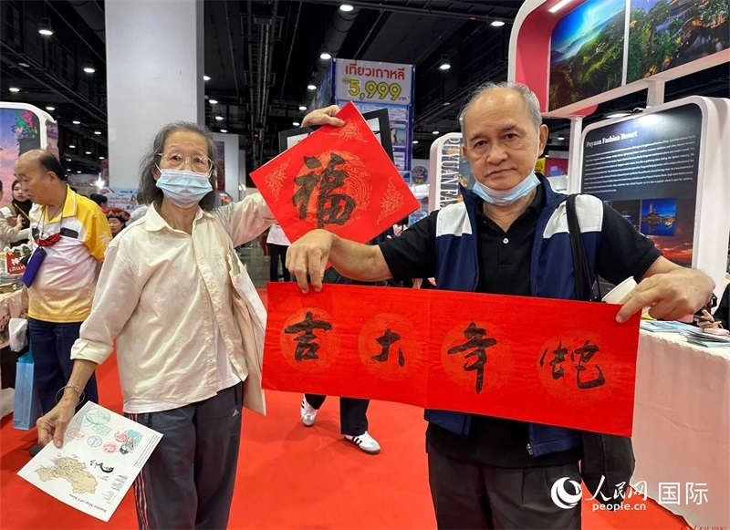 2025蛇年春節(jié)，泰國(guó)市民展示他們領(lǐng)到的華人手寫春聯(lián)。人民網(wǎng)記者 簡(jiǎn)承淵攝
