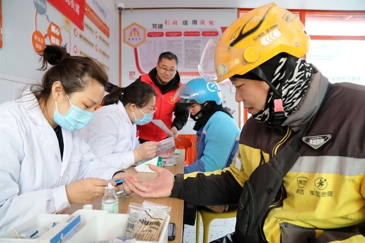 2025年3月5日，志愿者在山東省棗莊市市中區(qū)一工會驛站為外賣員免費測量血糖。新華社發(fā)（王海楠攝）