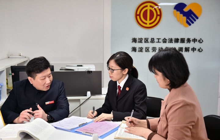 2025年3月6日，在北京市海淀區(qū)總工會勞動爭議調(diào)解中心，海淀區(qū)人民法院法官王琰（中）與該中心工作人員就糾紛化解情況進(jìn)行溝通。新華社記者 趙婷婷 攝