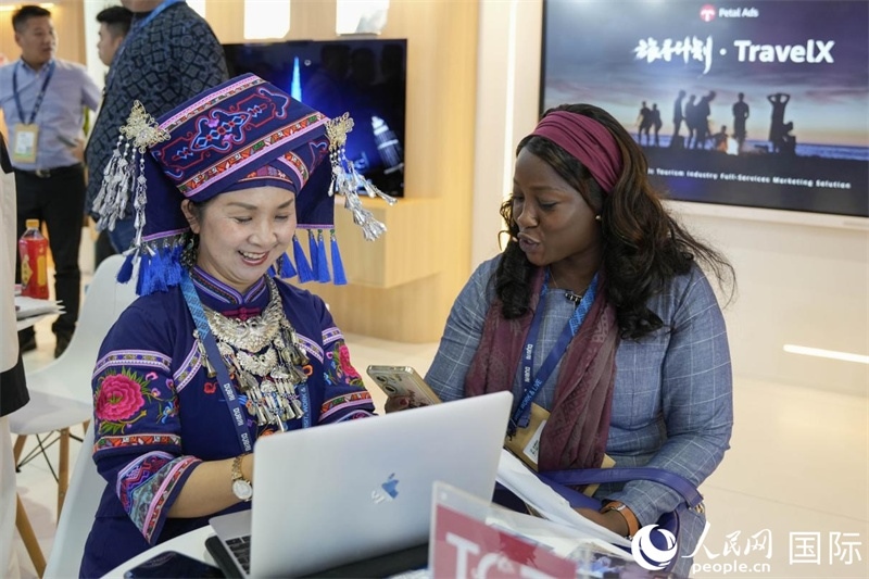 來(lái)自廣西的旅游業(yè)者同客戶(hù)交流。人民網(wǎng)塔里克·易卜拉欣攝
