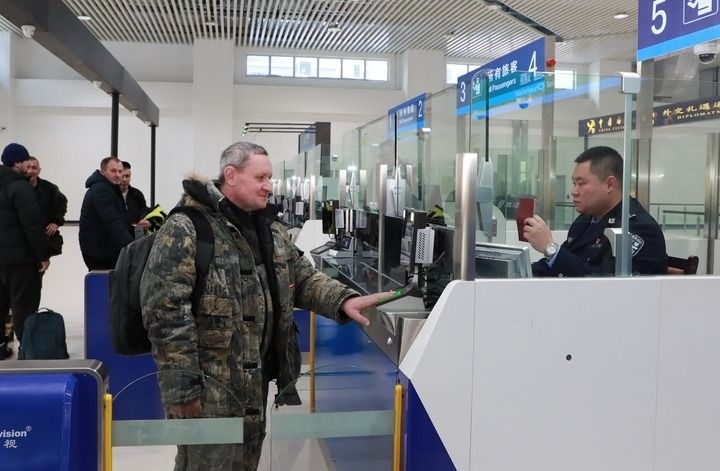 2024年12月10日，在黑河公路口岸旅檢大廳，黑河出入境邊防檢查站民警為首班次客車入境旅客辦理邊檢通關(guān)手續(xù)。當(dāng)日，中國黑河公路口岸—俄羅斯卡尼庫爾干公路口岸旅客運輸正式開通。新華社發(fā)（劉松攝）