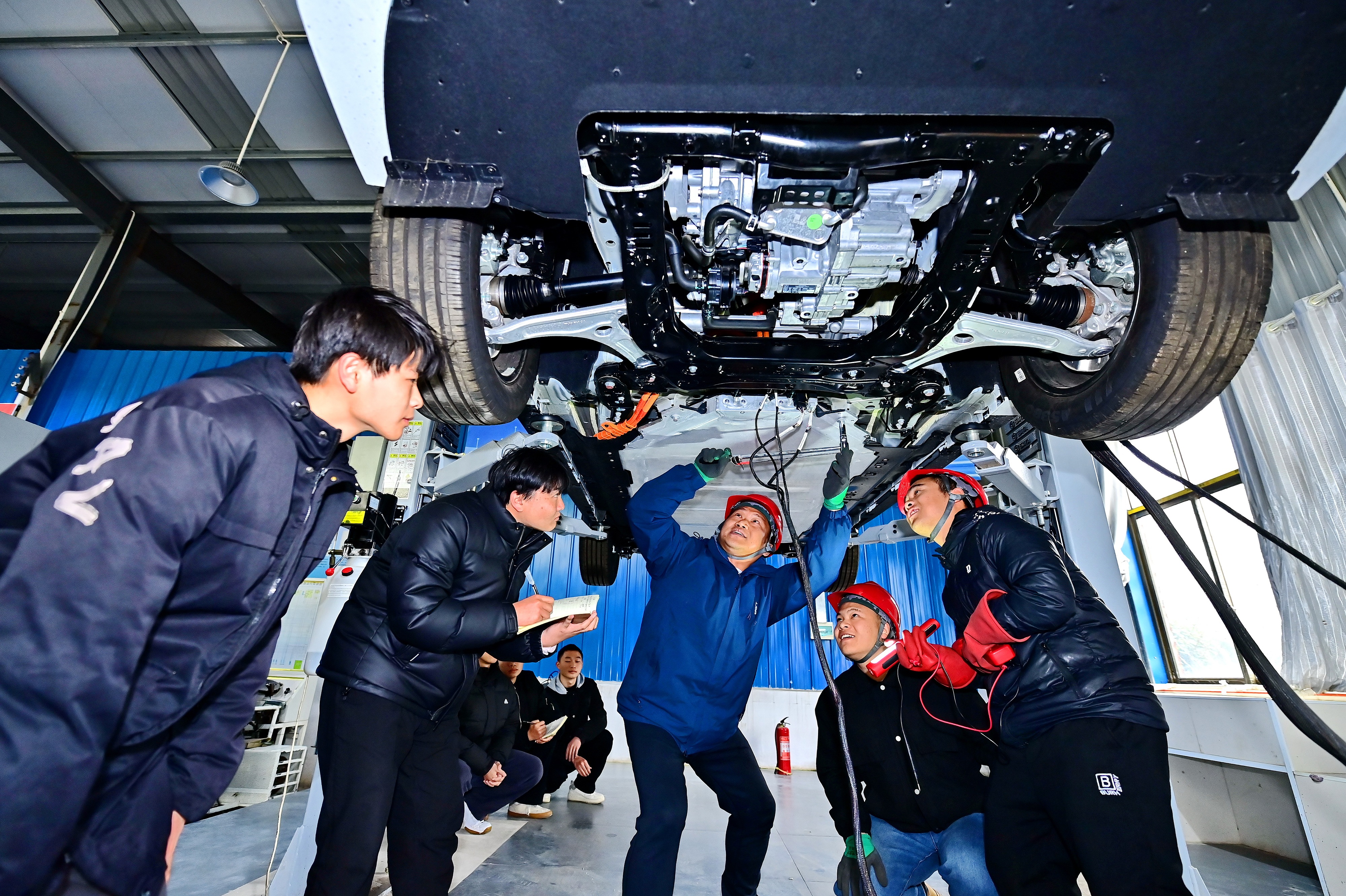 2025年2月，江西省宜春市，豐城市的一所技工學(xué)校實(shí)訓(xùn)基地內(nèi)，新能源汽車運(yùn)維專業(yè)學(xué)生在老師的指導(dǎo)下學(xué)習(xí)新能源汽車電池包檢修技術(shù)。