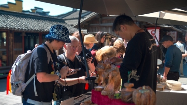 “五一”期間，游客正在烏鎮(zhèn)“水鄉(xiāng)碼頭”挑選購(gòu)買(mǎi)文創(chuàng)產(chǎn)品。受訪者供圖