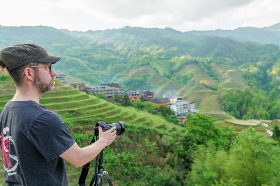 2025年年5月9日，廣西桂林，外國(guó)游客游覽龍脊梯田，在美景前駐足拍照。（圖片來(lái)源：視覺中國(guó)）