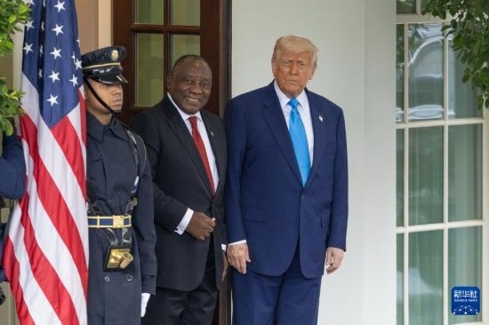 5月21日，美國(guó)總統(tǒng)特朗普（右）在華盛頓白宮迎接到訪(fǎng)的南非總統(tǒng)拉馬福薩（中）。新華社記者 胡友松 攝