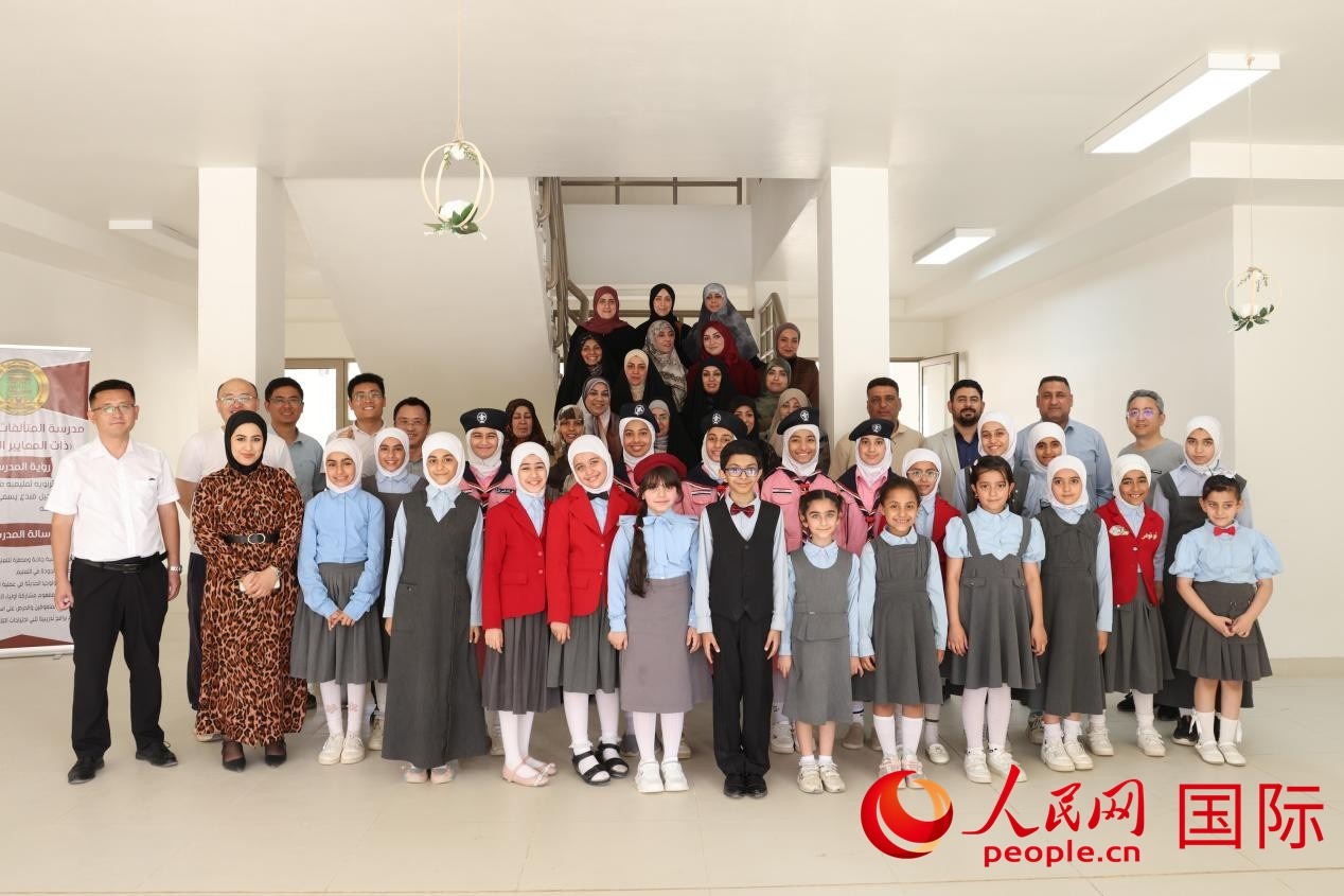 中國(guó)電建員工與阿爾穆塔?阿里卡特國(guó)際學(xué)校的師生及政府官員等合影。人民網(wǎng)記者 薛丹攝