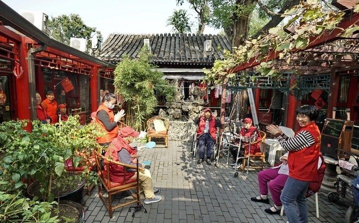 2024年10月12日，鐘樓灣胡同的老年人在社區(qū)內(nèi)的四合院養(yǎng)老驛站休閑。2017年起，北京市先后開展了兩輪背街小巷環(huán)境整治提升行動，完整保留了中軸線生活建筑群的歷史信息，并根據(jù)居民的生活和居住方式進行適配化的更新和改造，極大地改善了生活環(huán)境。2023年鐘樓灣胡同被評為“北京最美街巷”。