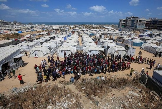 5月28日，人們在加沙城西部的沙提難民營等待領(lǐng)取救助食物。新華社發(fā)（里澤克·阿卜杜勒賈瓦德攝）