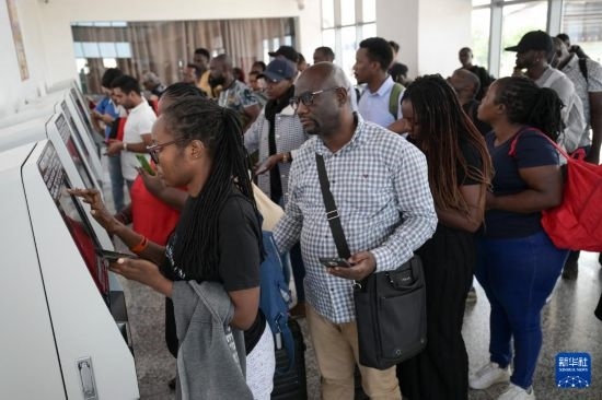 5月31日，在蒙內(nèi)鐵路內(nèi)羅畢站，乘客在自助取票機(jī)前排隊(duì)取票。新華社記者 楊光 攝