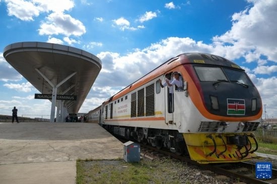 5月31日，在蒙內(nèi)鐵路內(nèi)羅畢站，機(jī)車駕駛員蔣立平（右）和博爾在即將開往蒙巴薩的E2次列車上揮手致意。新華社記者 楊光 攝