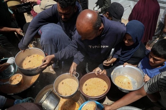 5月28日，人們在加沙城西部的沙提難民營領(lǐng)取救助食物。新華社發(fā)（里澤克·阿卜杜勒賈瓦德攝）