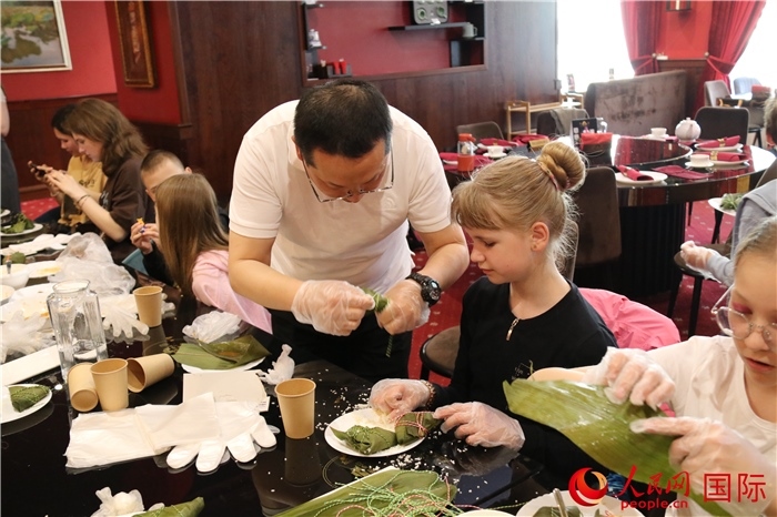 烏克蘭兒童學(xué)習(xí)體驗包粽子。人民網(wǎng)記者蔡子暢攝