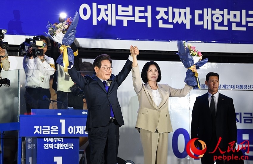 6月4日凌晨，確定當(dāng)選韓國(guó)總統(tǒng)的李在明舉手向歡呼的支持者們致意。 人民網(wǎng) 康炯彬攝